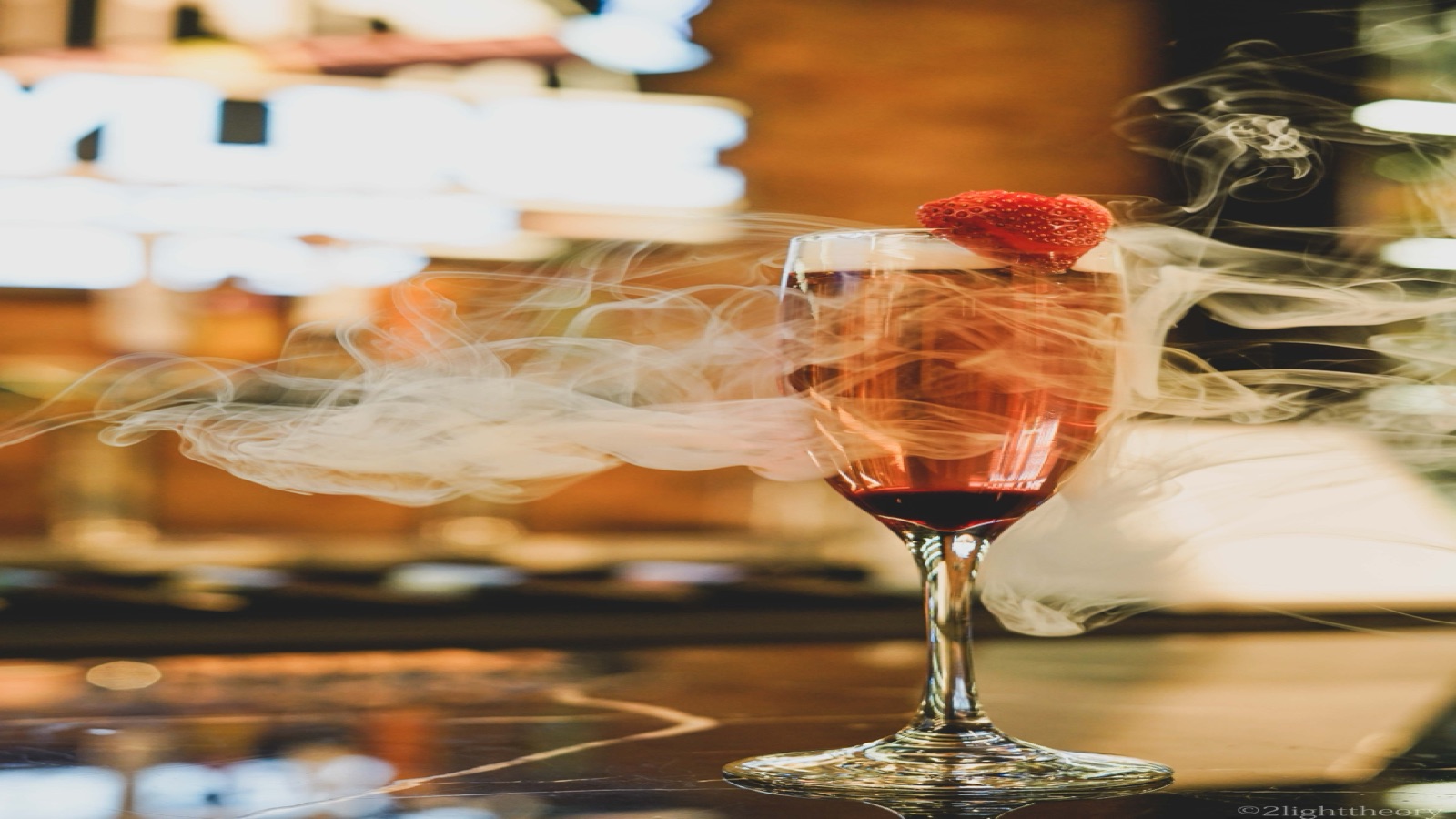 Smoke curling over a finished cocktail